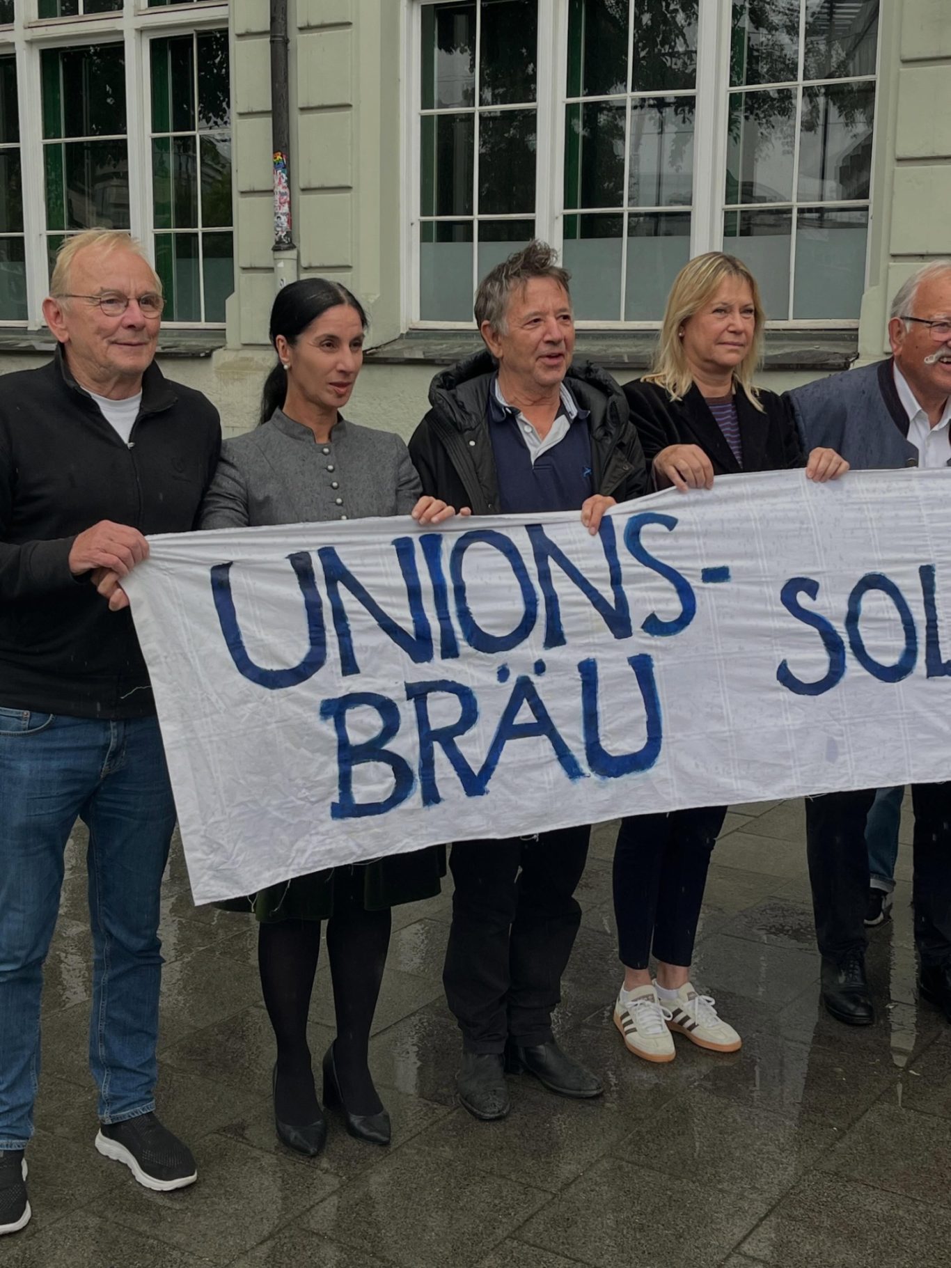 „Unionsbräu soll leben!“ Vor dem Unionsbräu: Die Bürgerinitiative und Unterstützer*innen stehen mit einem Banner in der Hand, auf dem steht: Unionsbräu soll leben.